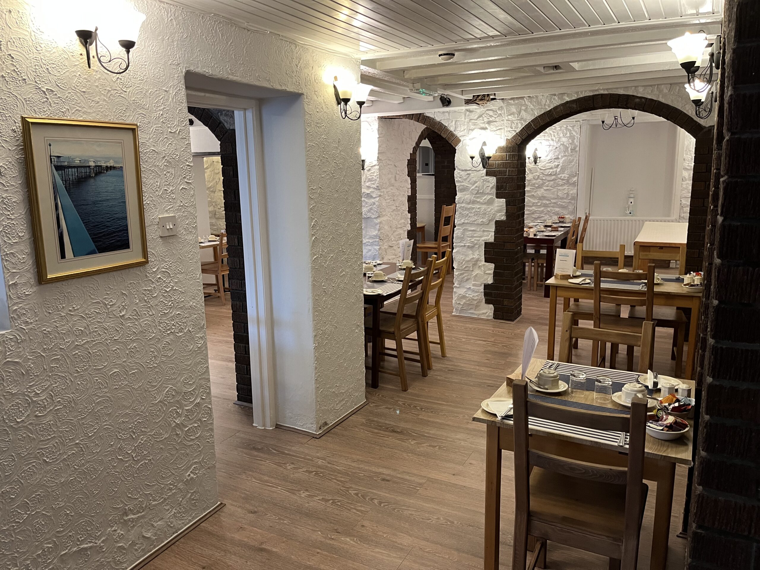 Dining room with stone archways and tables set for breakfast at The Oasis